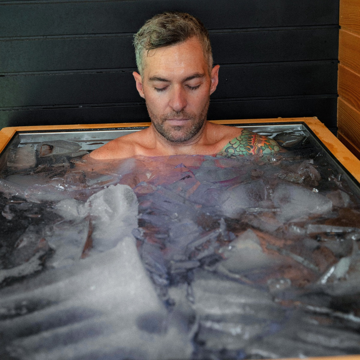 Man in an ice bath with a black background