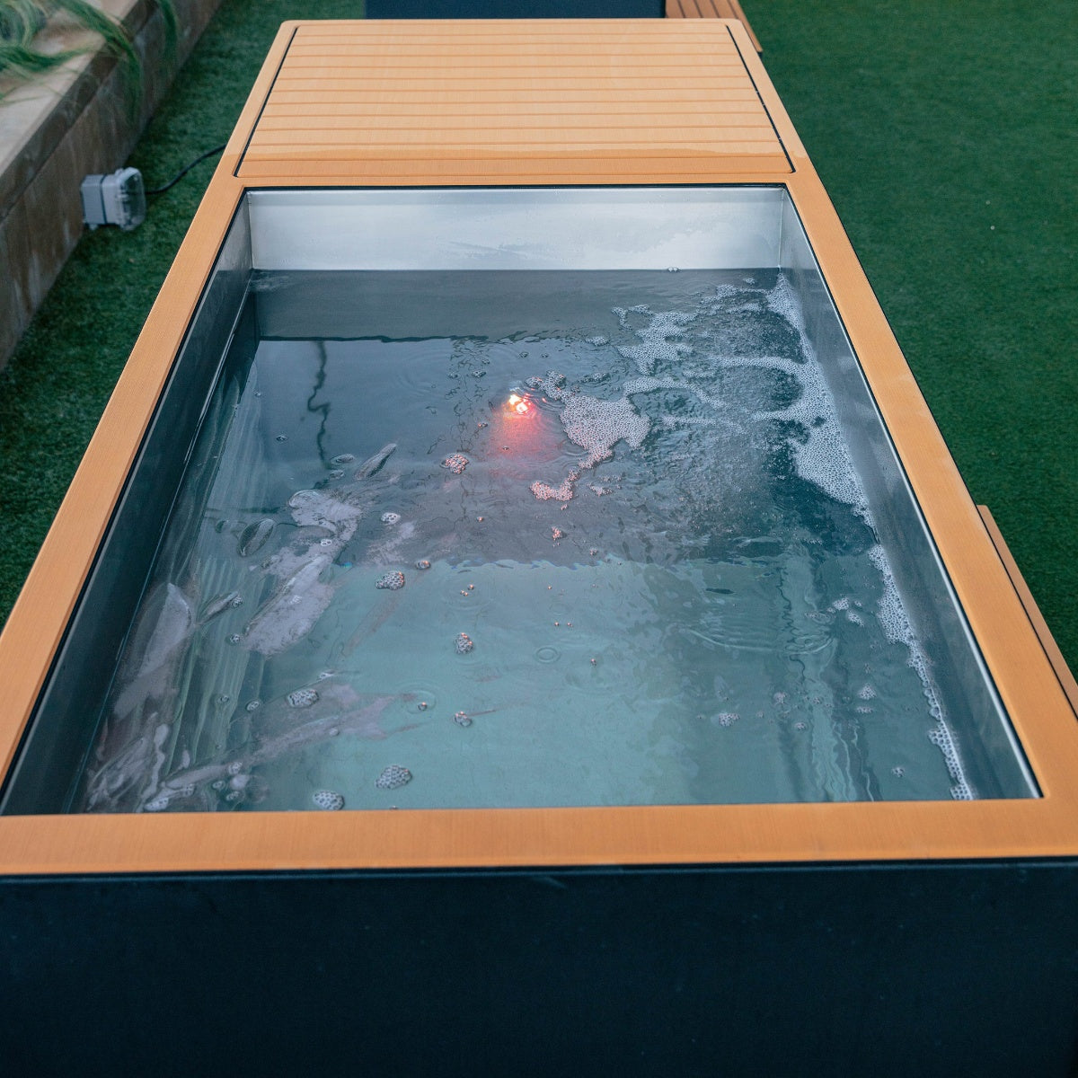 cold plunge with wooden exterior on a grassy area